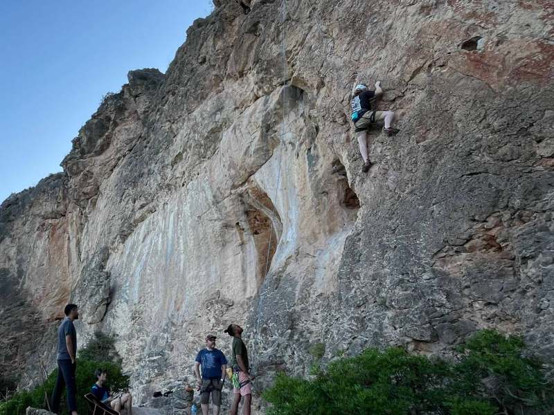 A climber on a cliff above the sea