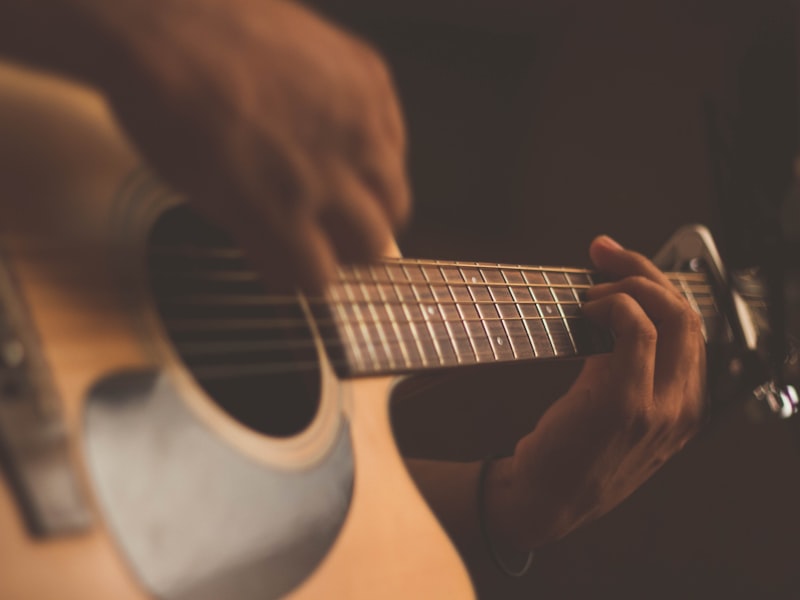 Hands playing an acoustic guitar